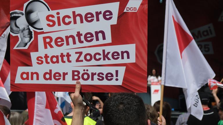 Ein Transparent mit dem Aufdruck «Sichere Renten statt Zocken an der Börse!» und Fahnen bei einer Veranstaltung des Deutschen Gewerkschaftsbundes zum 1. Mai