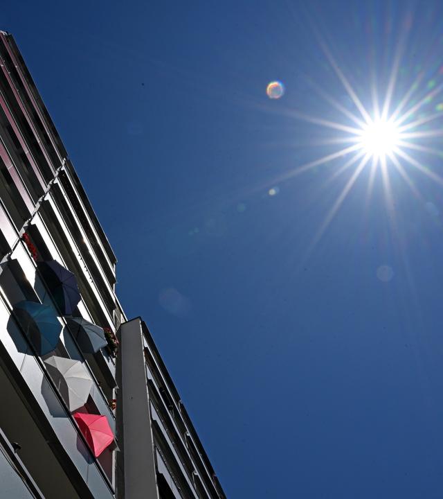 Jena: Mit Sonnenschirmen schützen Bewohner in einem Plattenbau in Jena-Lobeda die Wohnung vor der Hitze.