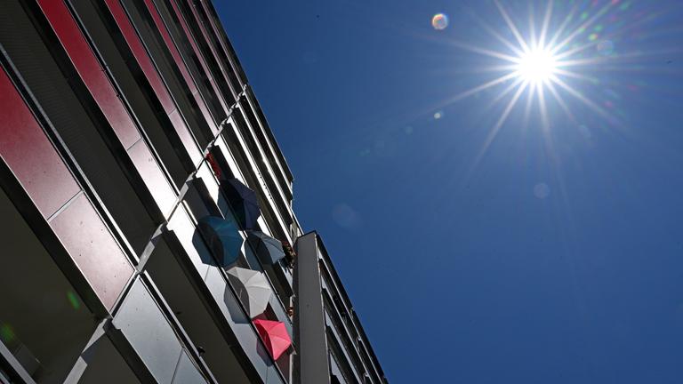 Jena: Mit Sonnenschirmen schützen Bewohner in einem Plattenbau in Jena-Lobeda die Wohnung vor der Hitze.