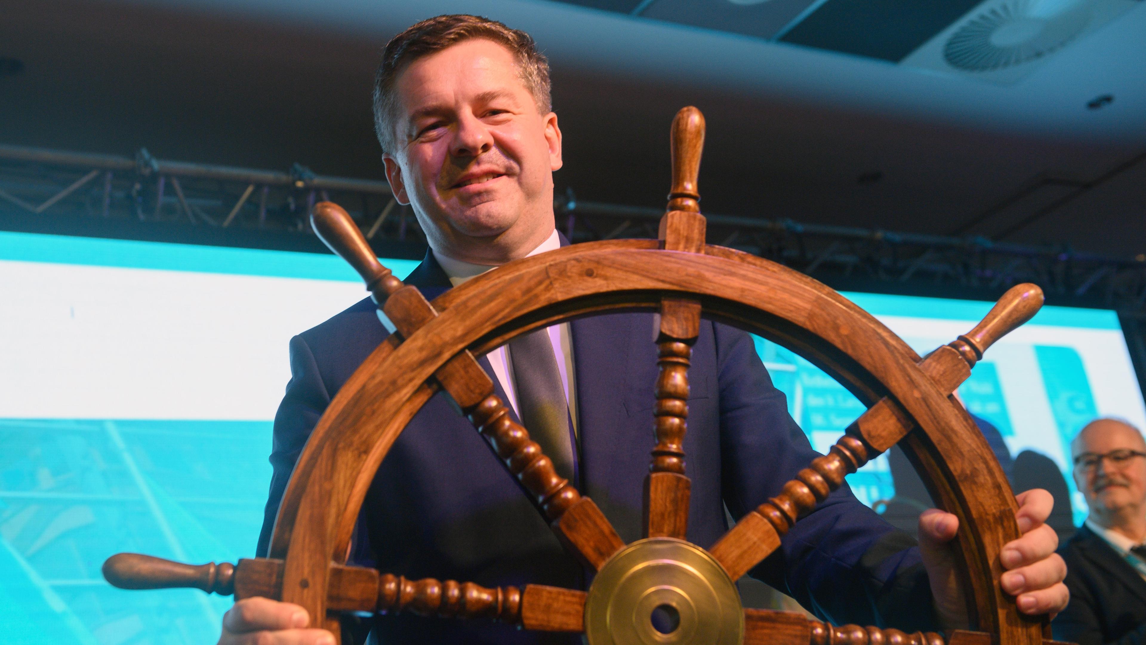 Sven Schulze (CDU), Minister für Wirtschaft, Tourismus, Landwirtschaft und Forsten des Landes Sachsen-Anhalt, steht mit einem Steuerrad auf der Bühne der Landesvertreterversammlung der CDU