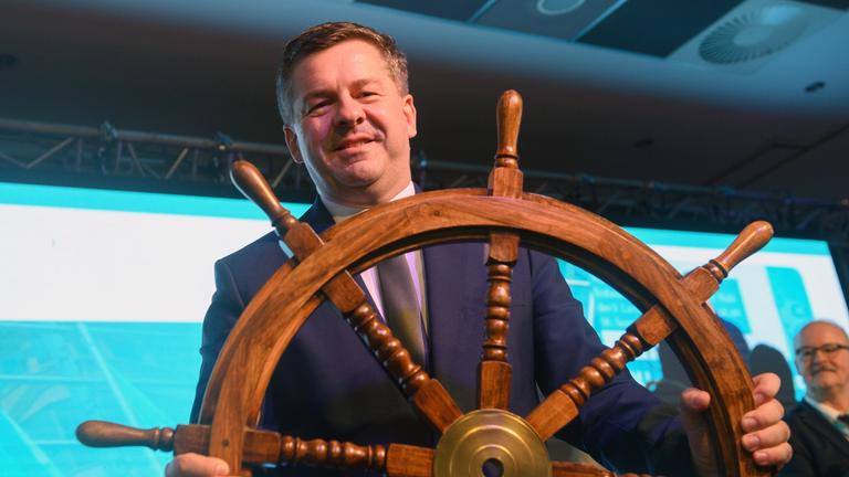 Sven Schulze (CDU), Minister für Wirtschaft, Tourismus, Landwirtschaft und Forsten des Landes Sachsen-Anhalt, steht mit einem Steuerrad auf der Bühne der Landesvertreterversammlung der CDU