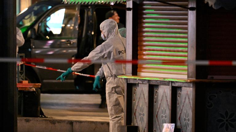Beamte der Spurensicherung untersuchen den Tatort in der Innenstadt. 