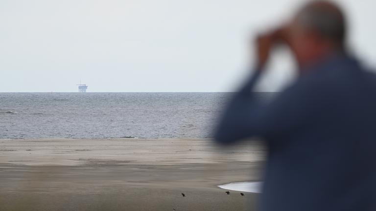 Ein Urlauber blickt auf die Gasplattform NO5-A des Unternehmens One-Dyas.