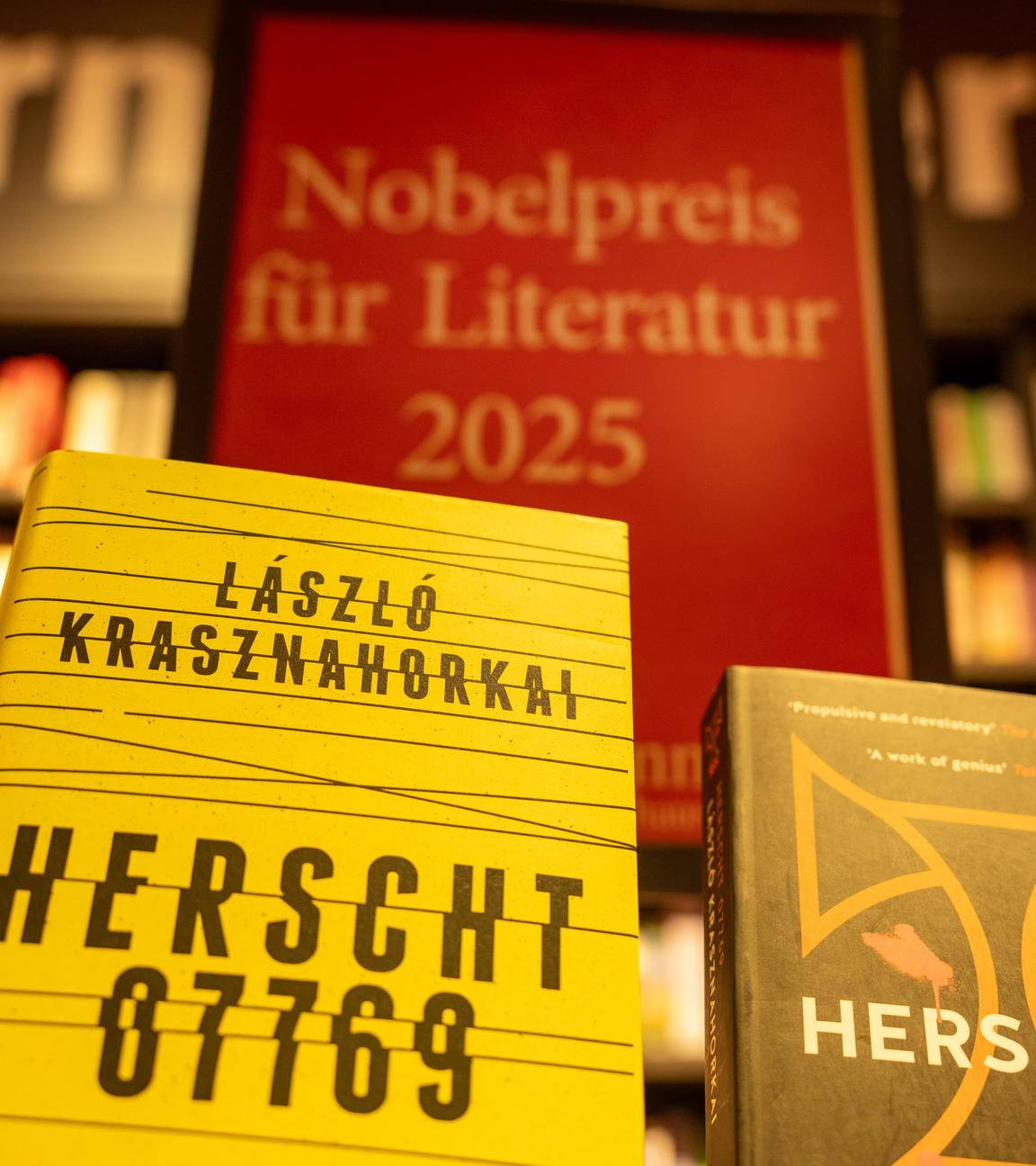  Bücher des ungarischen Schriftstellers László Krasznahorkai stehen im Berliner Kulturkaufhaus Dussmann vor einem vor einem Aufsteller mit der Aufschrift «Nobelpreis für Literatur 2025»