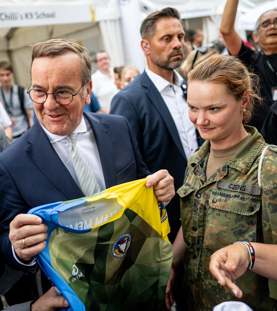 Boris Pistorius (SPD), Bundesminister der Verteidigung, bekommt am Nationalen Veteranentag auf dem Bürgerfest rund um das Reichstagsgebäude ein Trikot vom Laufteam Bundeswehr