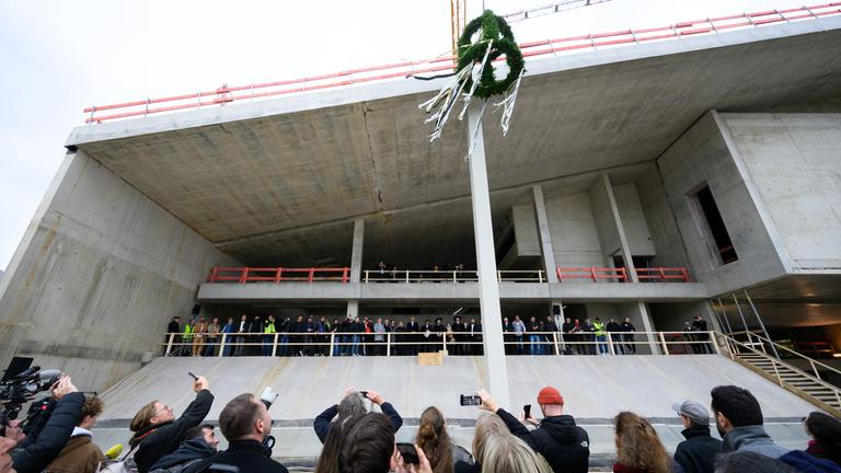 17.10.2025, Berlin: Der Richtkranz beim Richtfest für den Neubau des Museums Berlin Modern am Kulturforum in Berlin-Tiergarten von einem Kran hochgezogen. In dem Neubau mit gut 9000 Quadratmetern Fläche und in der benachbarten Neuen Nationalgalerie wird künftig die Sammlung zur Kunst des 20. Jahrhunderts ausgestellt.