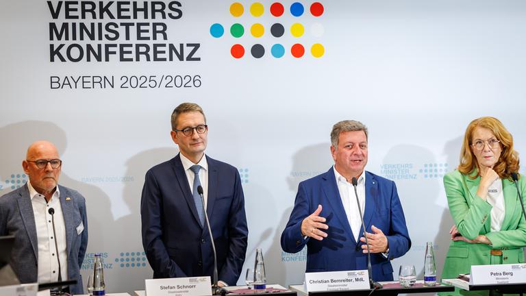 18.09.2025, Bayern, München: Christian Bernreiter (CSU, r), Staatsminister für Wohnen, Bau und Verkehr des Freistaats Bayern und Vorsitzender der Verkehrsministerkonferenz, spricht während der Pressekonferenz nach der Sonderverkehrsministerkonferenz neben Winfried Hermann (Bündnis 90/Die Grünen, l), Verkehrsminister von Baden-Württemberg, Stefan Schnorr, Staatssekretär im Bundesministerium für Verkehr, und Petra Berg (SPD), Ministerin für Umwelt, Klima, Mobilität, Agrar und Verbraucherschutz im Saarland.