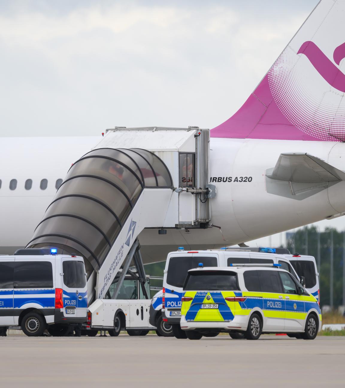 Polizeifahrzeug fahren auf dem Flughafen Leipzig/Halle an einem Airbus vor. Am Flughafen steht möglicherweise erneut ein Abschiebeflug bevor.