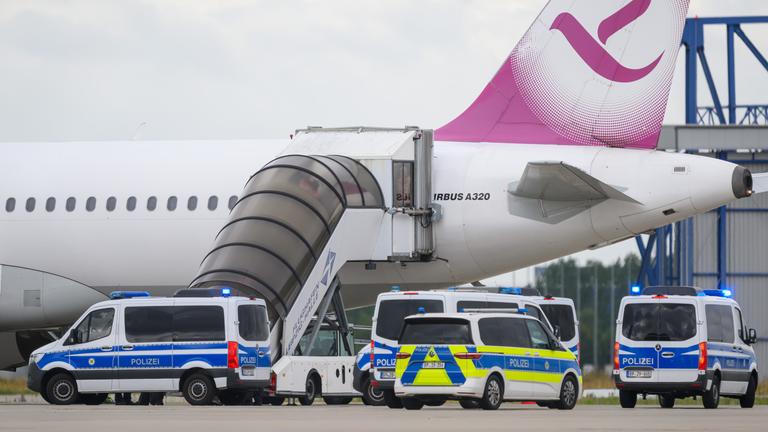 Polizeifahrzeug fahren auf dem Flughafen Leipzig/Halle an einem Airbus vor. Am Flughafen steht möglicherweise erneut ein Abschiebeflug bevor.