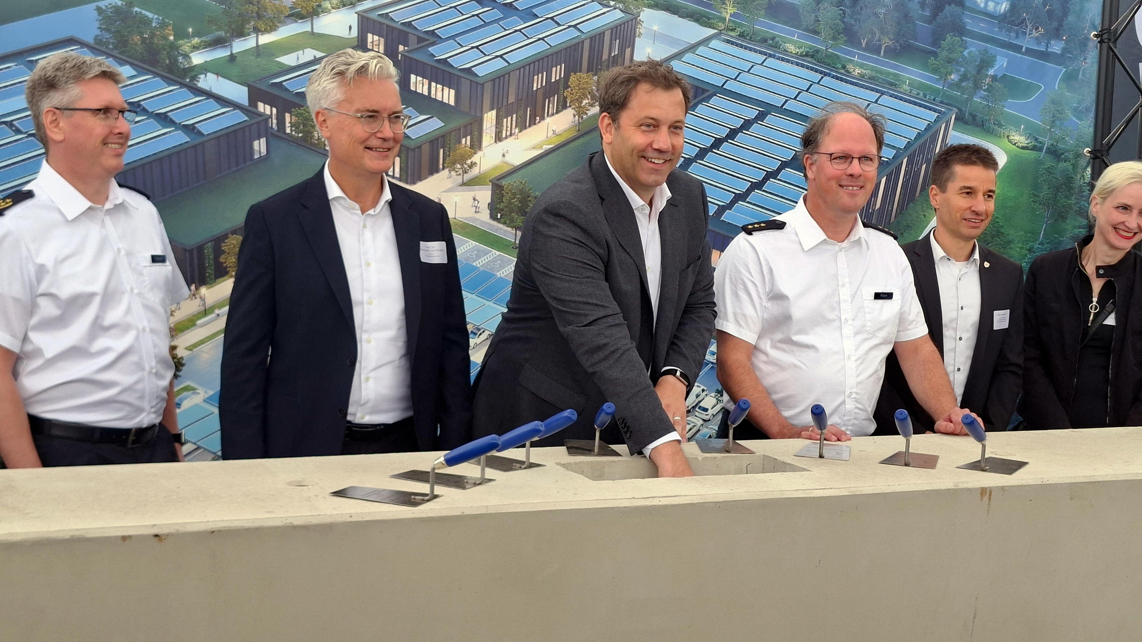 Lars Klingbeil (SPD, 3.v.l.), Bundesminister der Finanzen und Vizekanzler, steht bei der Grundsteinlegung für ein Einsatztrainingszentrum des Zolls