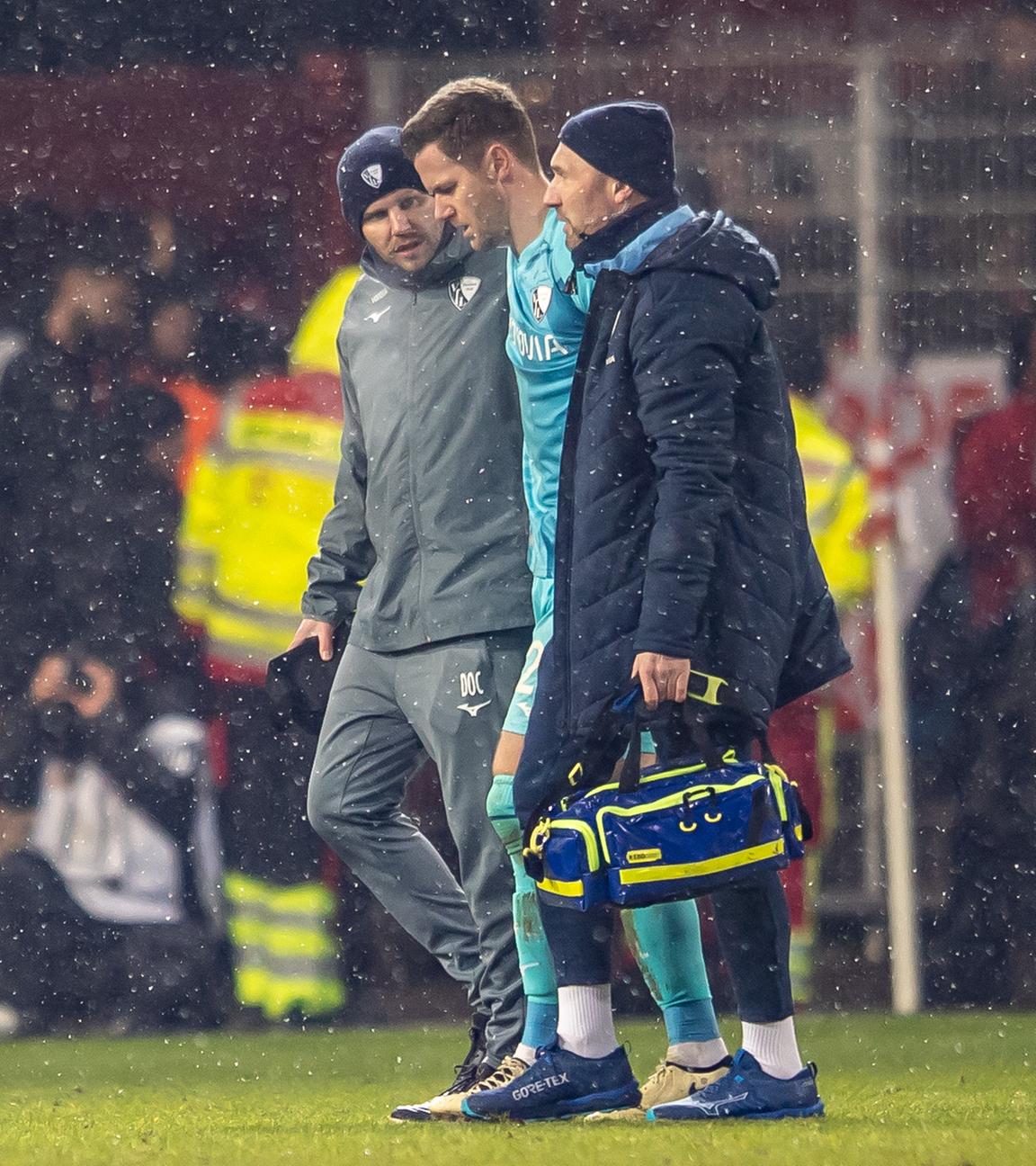 Bochum-Keeper Patrick Drewes wird von Betreuern vom Platz geführt, nachdem ihn im Spiel bei Union Berlin ein Feuerzeug am Kopf getroffen hatte.