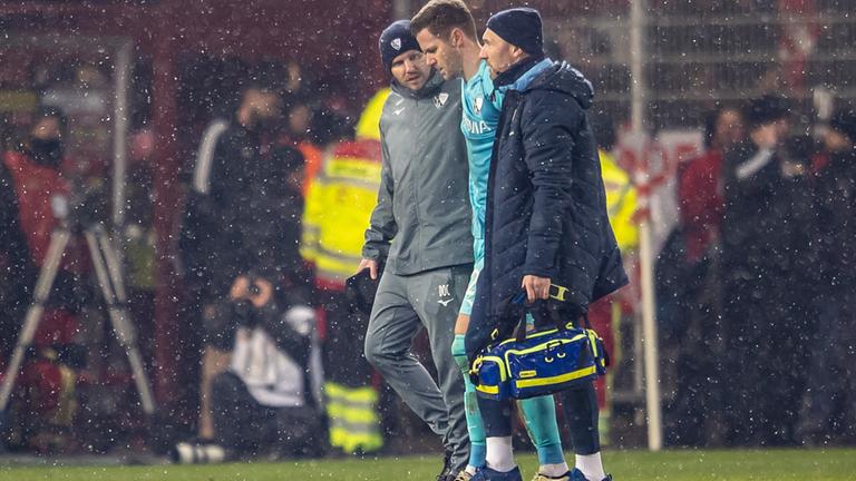 Bochum-Keeper Patrick Drewes wird von Betreuern vom Platz geführt, nachdem ihn im Spiel bei Union Berlin ein Feuerzeug am Kopf getroffen hatte.