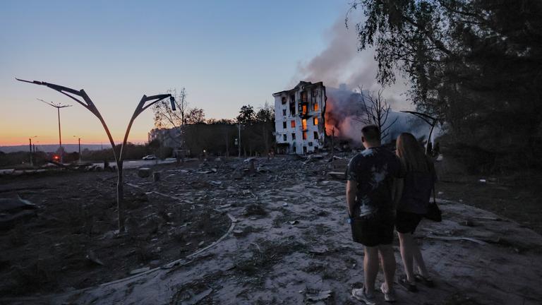 Ukraine, Kramatorsk: Einheimische betrachten ein durch einen russischen Luftangriff zerstörtes Wohnhaus.