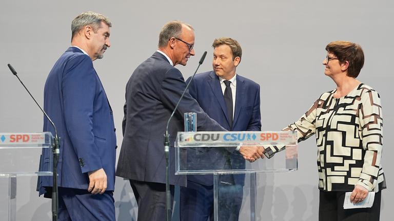  Friedrich Merz (2.v.l), Unions-Kanzlerkandidat und CDU-Bundesvorsitzender, und Saskia Esken (r), SPD-Bundesvorsitzende, geben sich neben Markus Söder (l), Ministerpräsident von Bayern und CSU-Vorsitzender, und Lars Klingbeil, SPD-Fraktions- und Bundesvorsitzender, nach einer Pressekonferenz der Parteivorsitzenden von Union und SPD zur Vorstellung des Koalitionsvertrages im Paul-Löbe-Haus die Hand.