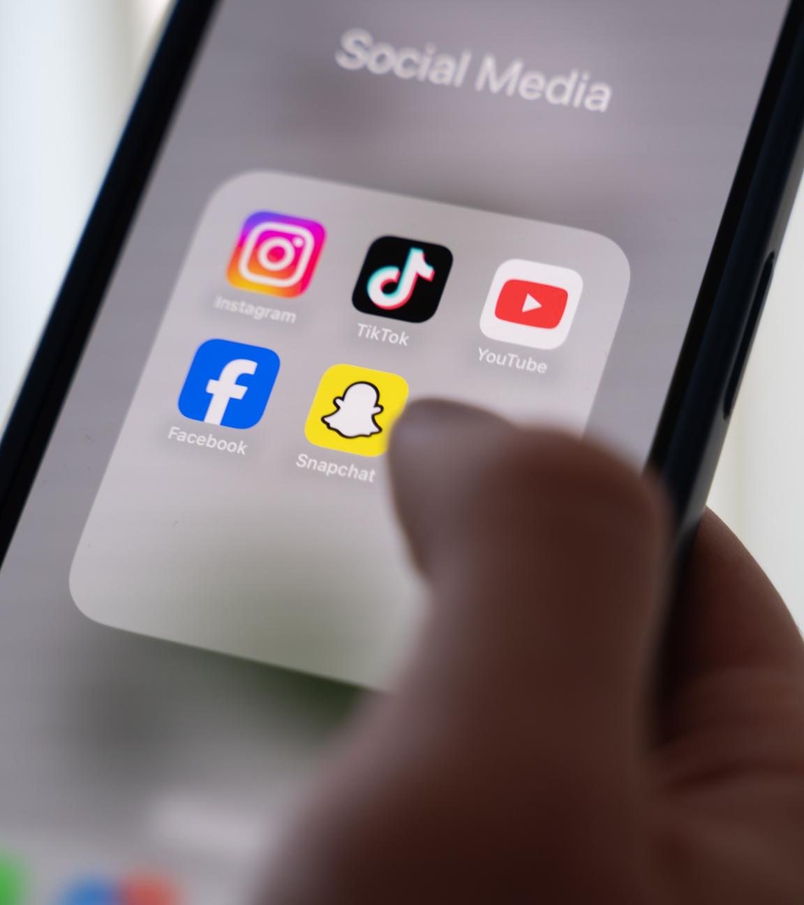 Eine Frau hält ein Smartphone, auf dessen Display verschiedene Social Media Apps angezeigt werden. (zu dpa: «Belangloses in Serie  Scrollen Kinder sich um den Verstand?») 