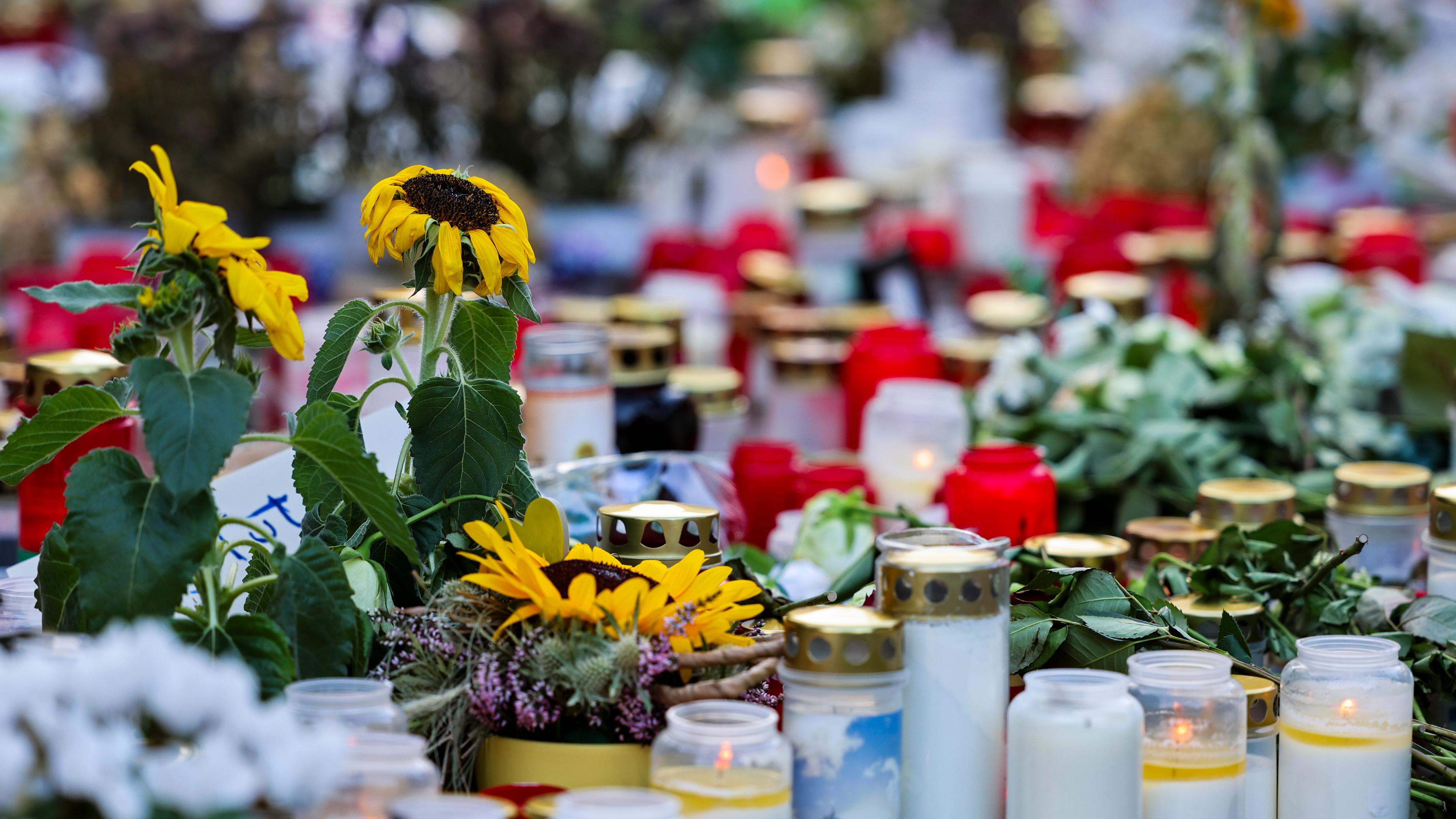 Nordrhein-Westfalen, Solingen: Kerzen und Blumen liegen unweit des Tatorts am Fronhof zum Gedenken an die Opfer der Messerattacke auf dem Solinger Stadtfest. Beim mutmaßlich islamistischen Anschlag von Solingen hatte ein Angreifer auf einem Stadtfest drei Menschen mit einem Messer getötet und acht weitere verletzt