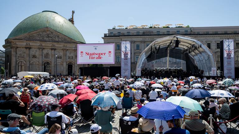 22.06.2025, Berlin: Menschen verfolgen bei hohen Temperaturen das Open-Air Konzert der «Staatsoper für alle» der Staatskapelle Berlin.