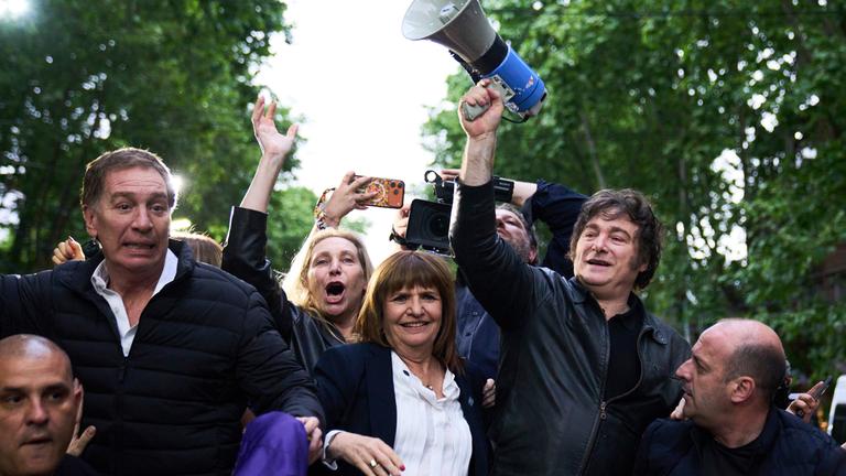 ARCHIV - 17.10.2025, Argentinien, Buenos Aires: Argentiniens Präsident Javier Milei hält ein Megaphon in der Hand, während er eine Wahlkampfveranstaltung vor den Parlamentswahlen anführt. Er wird begleitet von dem Kandidaten Diego Santilli (2.v.l), der Generalsekretärin der Präsidentschaft Karina Milei und der Sicherheitsministerin Patricia Bullrich in Tres de Febrero.