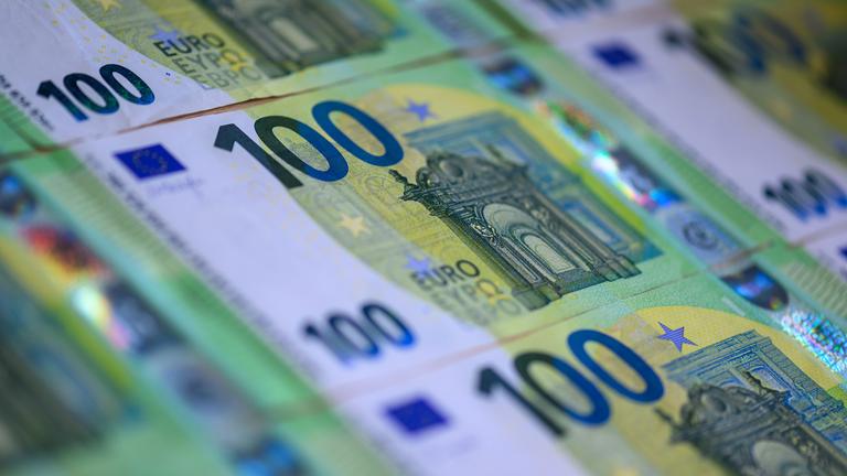  Mehrere 100 Euro Banknoten liegen auf einem Tisch.