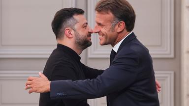 Frankreich, Paris: Frankreichs Präsident Emmanuel Macron (r) umarmt den ukrainischen Präsidenten Wolodymyr Selenskyj am Ende einer Pressekonferenz nach einem Gipfeltreffen zur Ukraine im Elysee-Palast.