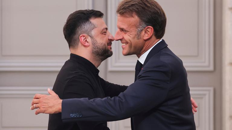 Frankreich, Paris: Frankreichs Präsident Emmanuel Macron (r) umarmt den ukrainischen Präsidenten Wolodymyr Selenskyj am Ende einer Pressekonferenz nach einem Gipfeltreffen zur Ukraine im Elysee-Palast.