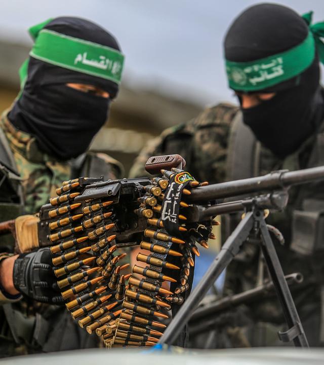 Hamas-Krieger mit einem schweren Maschinengewehr bei der Freilassung dreier Geiseln