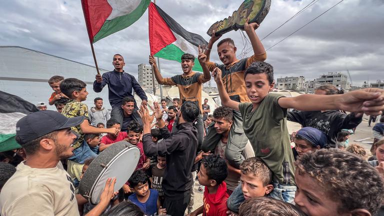 Palästinensische Gebiete, Nusairat: Palästinenser feiern im Lager Nusairat nach der Bekanntgabe, dass Israel und die Hamas der ersten Phase eines Friedensplans zur Unterbrechung der Kämpfe zugestimmt haben