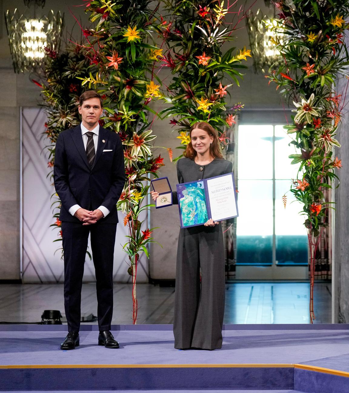 na Corina Sosa, Tochter der Friedensnobelpreisträgerin Maria Corina Machado, nimmt den Preis stellvertretend für ihre Mutter im Rathaus von Oslo entgegen. Kristian Berg Harpviken, Direktor des Nobelinstituts, steht neben ihr.