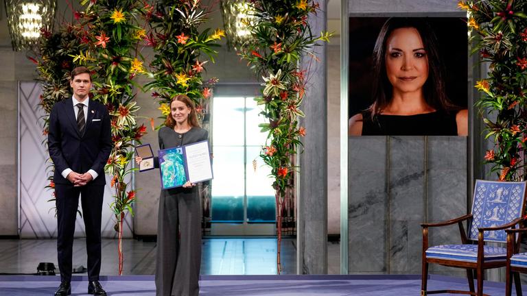 na Corina Sosa, Tochter der Friedensnobelpreisträgerin Maria Corina Machado, nimmt den Preis stellvertretend für ihre Mutter im Rathaus von Oslo entgegen. Kristian Berg Harpviken, Direktor des Nobelinstituts, steht neben ihr.