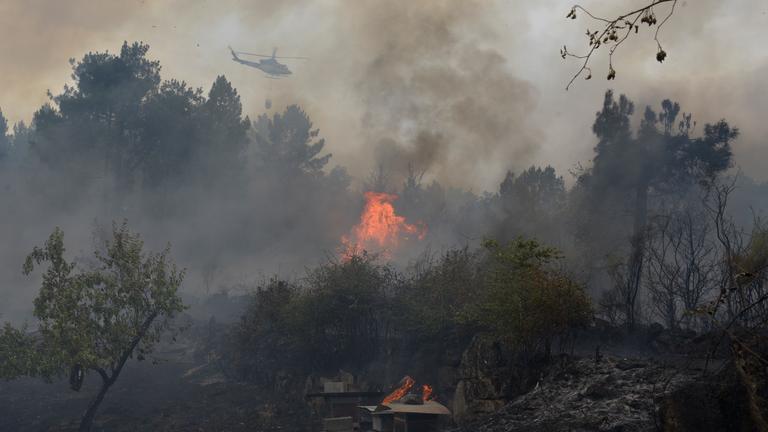 Spanien, Seixalbo: Ein Hubschrauber versucht, das Feuer in Seixalbo zu löschen. 
