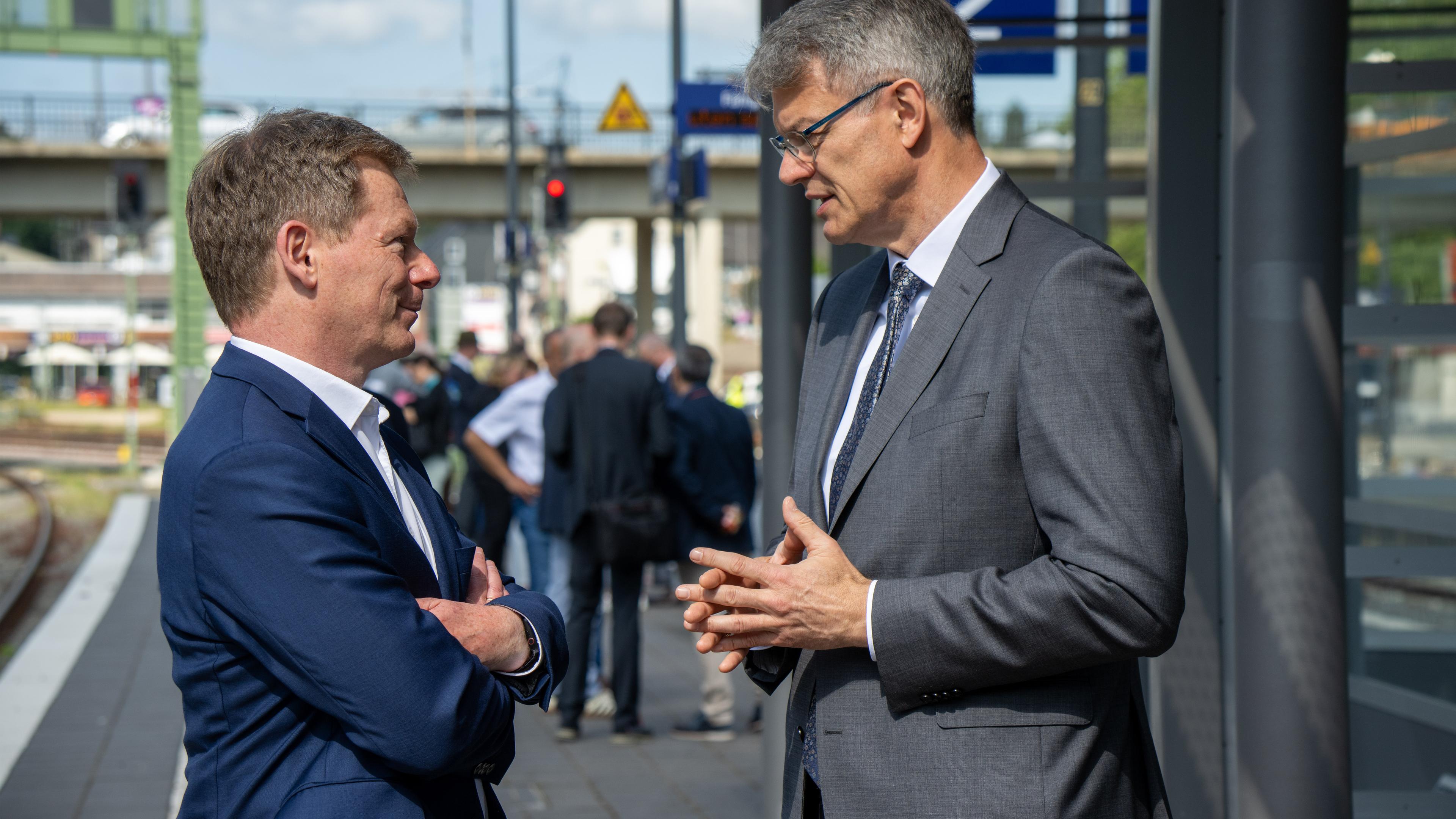 Bundesverkehrsminister Patrick Schnieder (r, CDU) und der Vorstandsvorsitzende der Deutschen Bahn, Richard Lutz, unterhalten sich be einem Pressetermin