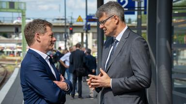 Bundesverkehrsminister Patrick Schnieder (r, CDU) und der Vorstandsvorsitzende der Deutschen Bahn, Richard Lutz, unterhalten sich be einem Pressetermin