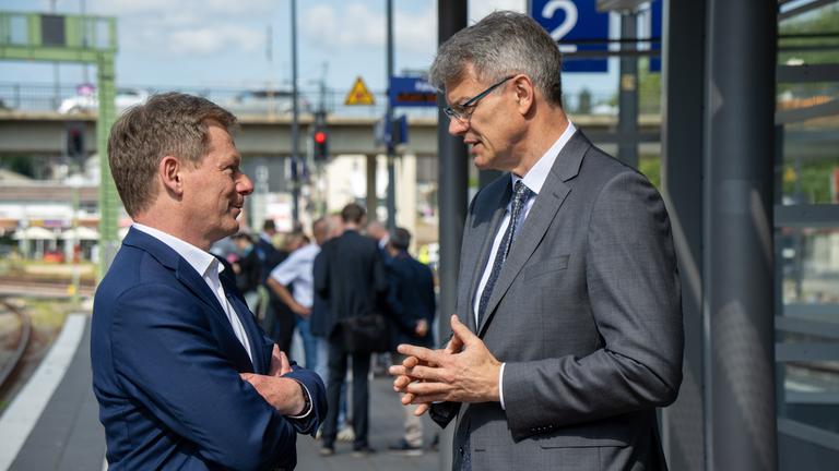Bundesverkehrsminister Patrick Schnieder (r, CDU) und der Vorstandsvorsitzende der Deutschen Bahn, Richard Lutz, unterhalten sich be einem Pressetermin