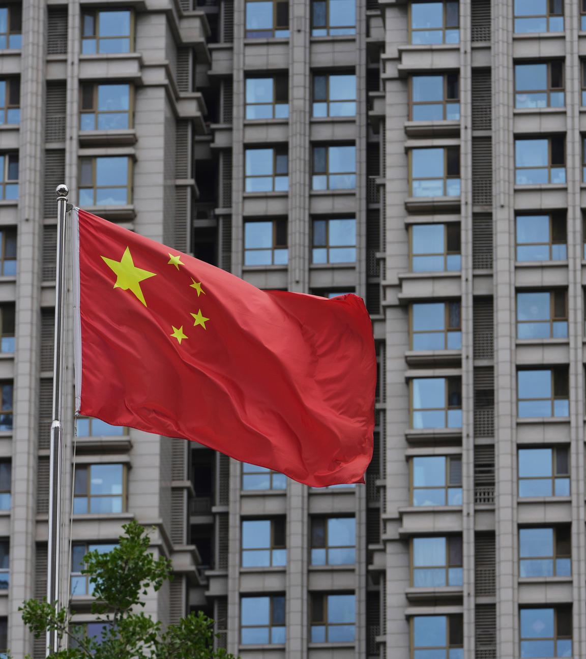 China, Peking: Eine chinesische Nationalflagge weht vor einem Wohngebäude in Peking