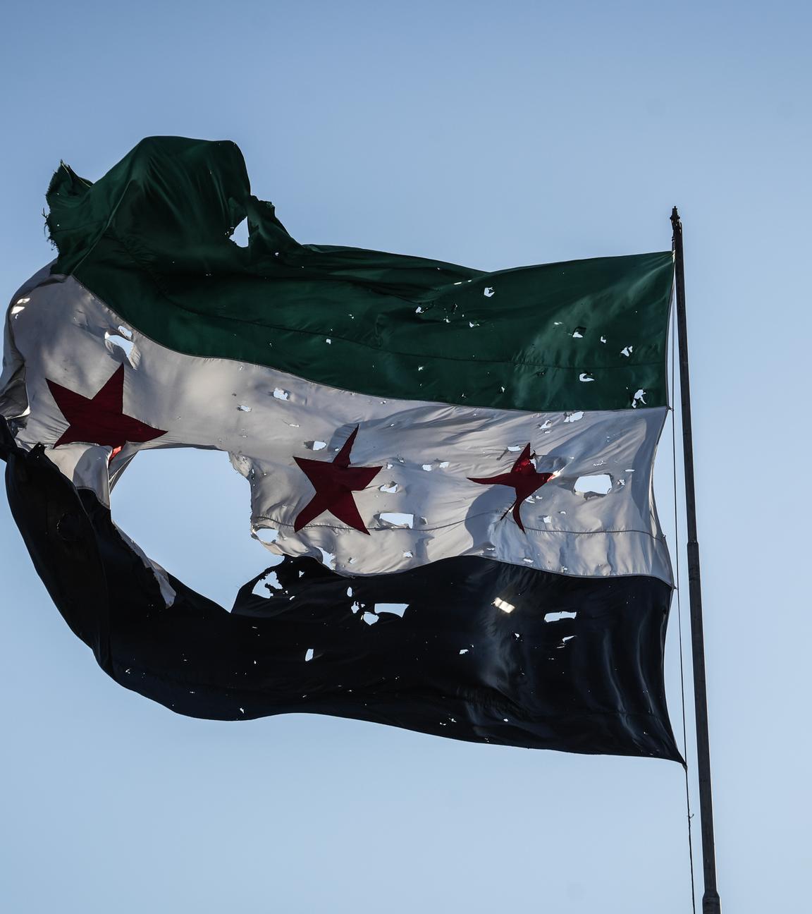 Durschlöcherte syrische Flagge vor dem Generalstabshauptquartier