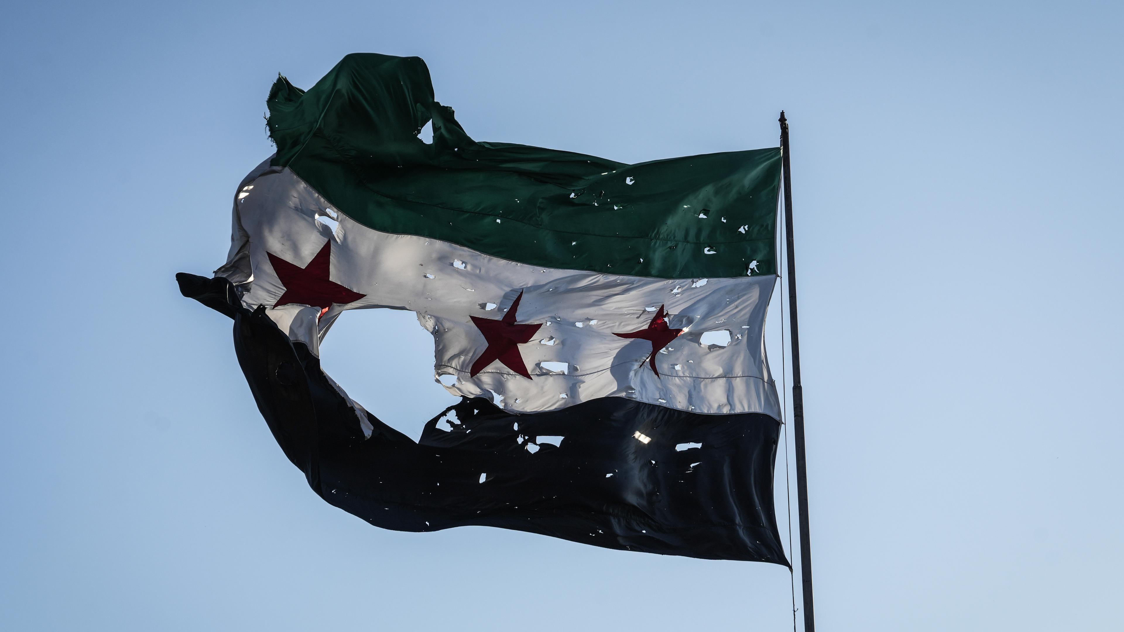 Durschlöcherte syrische Flagge vor dem Generalstabshauptquartier