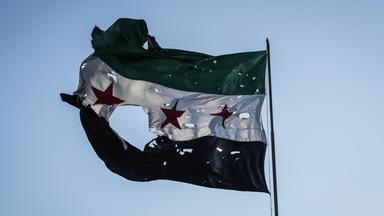 Durschlöcherte syrische Flagge vor dem Generalstabshauptquartier