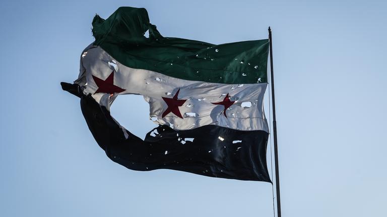 Durschlöcherte syrische Flagge vor dem Generalstabshauptquartier