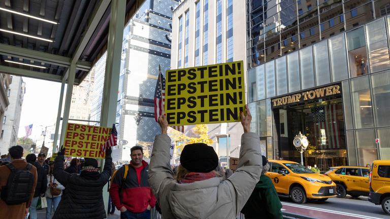  Friedliche Anti-Trump-Demonstranten skandieren mit Schildern und Transparenten vor dem Trump Tower, während Autos, Touristen und Einkäufer auf der Fifth Ave. vorbeifahren. Die Demonstranten von "Rise and Resist" halten amerikanische Flaggen und Schilder mit der Aufschrift "EPSTEIN! EPSTEIN! EPSTEIN! EPSTEIN!", während sie mit den Slogans "No Troops In Our Cities We Need Food and Healthcare Not Ballrooms" demonstrieren.