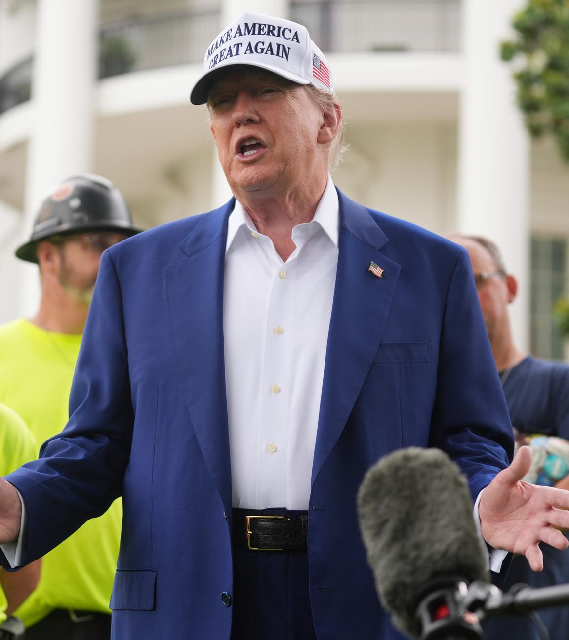 18.06.2025, USA, Washington: US-Präsident Donald Trump spricht zu Arbeitern, während ein Flaggenmast auf dem Südrasen des Weißen Hauses installiert wird.