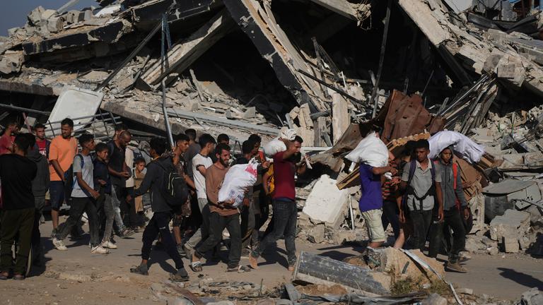 Palästinenser tragen humanitäre Hilfspakete in der Nähe des Verteilungszentrums der Gaza Humanitarian Foundation, das von der von den USA unterstützten Organisation im südlichen Gazastreifen betrieben wird.