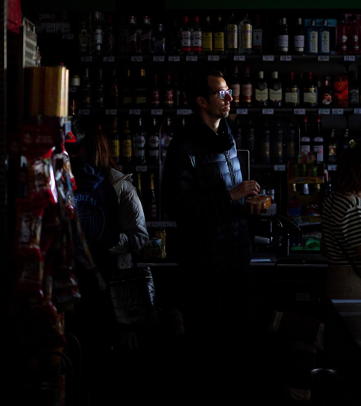 Während eines massiven Stromausfalls stehen Menschen in einem Supermarkt Schlange, um mit Bargeld zu bezahlen.