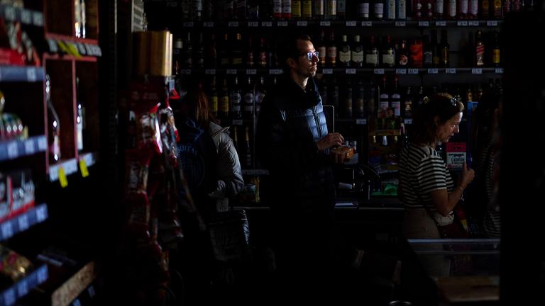 Während eines massiven Stromausfalls stehen Menschen in einem Supermarkt Schlange, um mit Bargeld zu bezahlen.