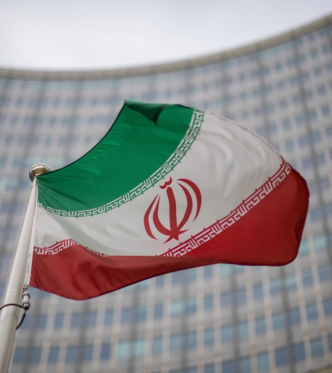 Eine iranische Nationalflagge weht vor dem Gebäude der Internationalen Atomenergiebehörde (IAEO). (zu dpa: «Europäer aktivieren Mechanismus für Sanktionen gegen Iran»)