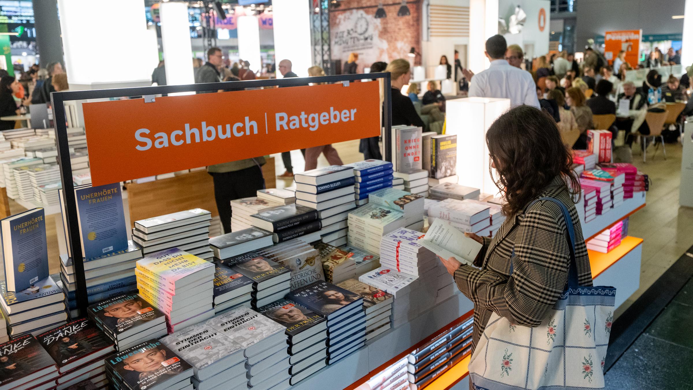 Eine Besucherin schaut sich an einem Verlagsstand Bücher an. Die 77. Frankfurter Buchmesse findet vom 15. bis 19. Oktober 2025 statt. Ehrengast sind die Philippinen.