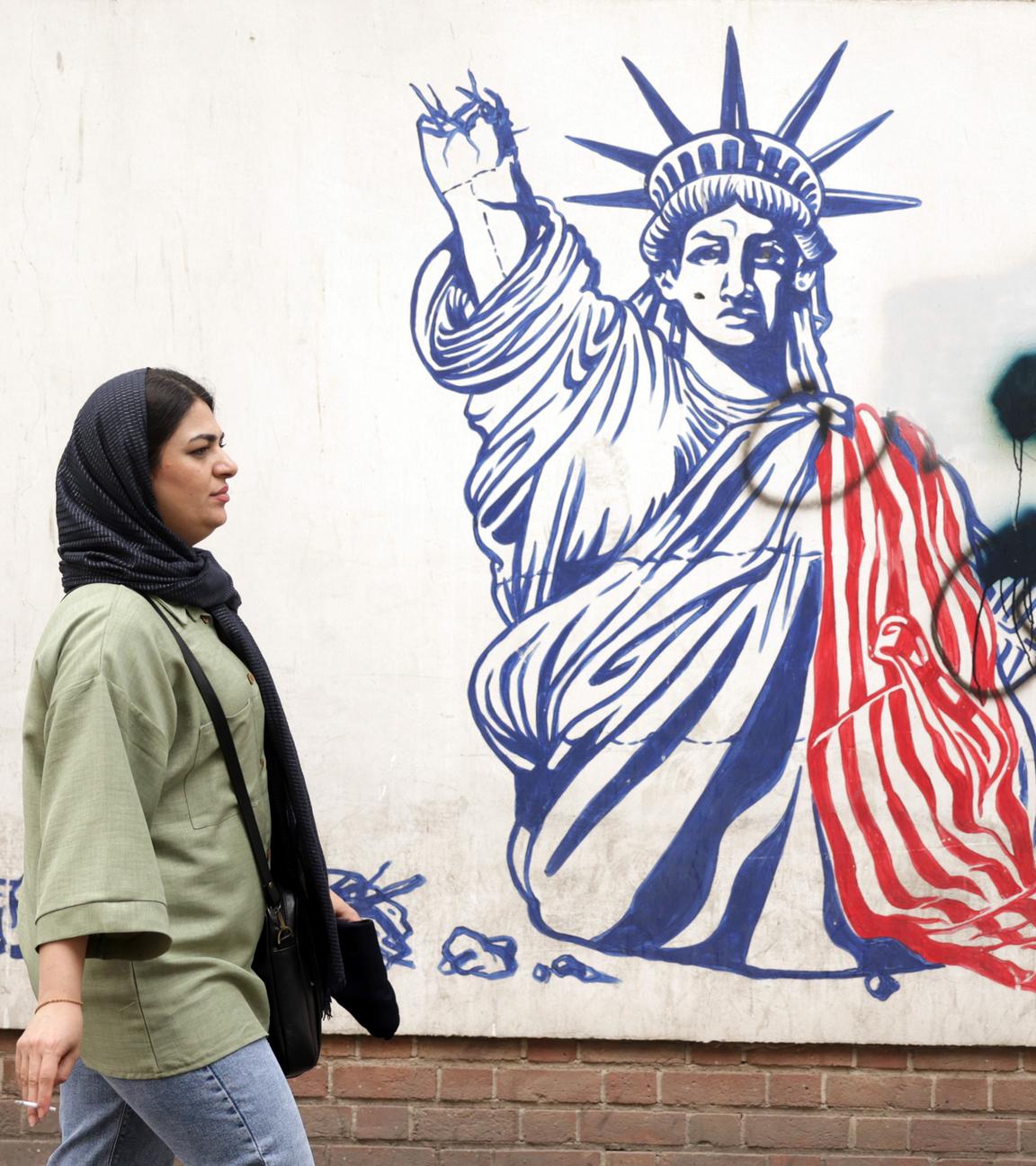 Eine Frau geht neben einem Anti-US-Wandbild neben der ehemaligen US-Botschaft in Teheran spazieren