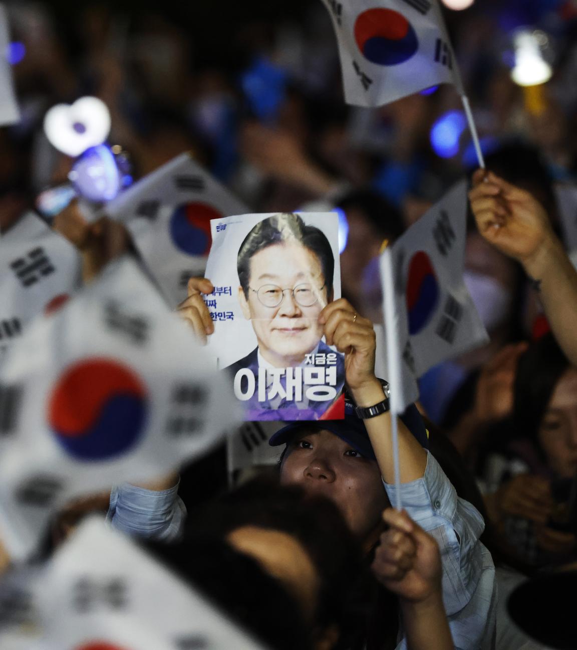 Anhänger von Lee Jae-Myung von der Demokratischen Partei reagieren, während sie nach Abschluss der Präsidentschaftswahlen in Seoul, Südkorea, die Auszählung der Wahlergebnisse verfolgen.
