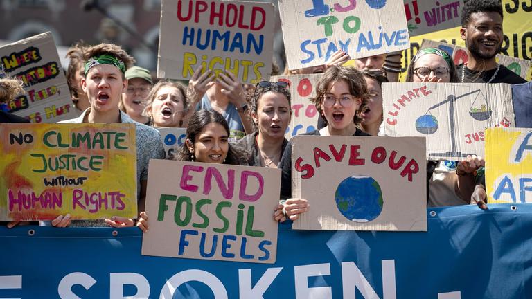 Demonstranten mit Schildern stehen vor dem Internationalen Gerichtshof in Den Haag, Niederlande, am 23. Juli 2025 vor der Entscheidung über ein Gutachten zu den Verpflichtungen der Länder zum Schutz des Klimas. Das Urteil ist nicht bindend, hat aber „großes rechtliches Gewicht und moralische Autorität“.
