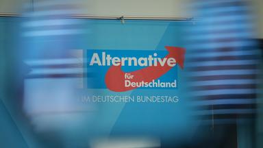 Das Logo der Partei und Fraktion Alternative für Deutschland (AfD) hinter einer Szene mit Smartphones während einer Medienerklärung der AfD-Fraktion im Deutschen Bundestag in Berlin am 15.09.2025