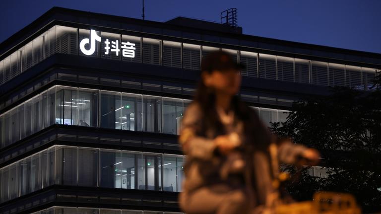  Eine Frau fährt mit dem Fahrrad an einem Gebäude mit dem Douyin-Logo in Peking, China, vorbei, 19. September 2025. Die Douyin-App ist das chinesische Pendant zu TikTok. Am 19. September sollten die Präsidenten der USA und Chinas ein Telefongespräch führen, um unter anderem eine Vereinbarung zu finalisieren, die es der Social-Media-App TikTok ermöglicht, ihren Betrieb in den USA fortzusetzen.